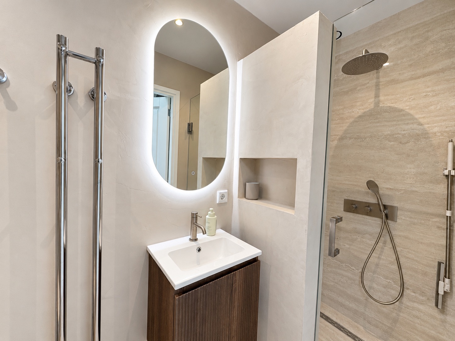 The bathroom with illuminated mirror and walk-in shower