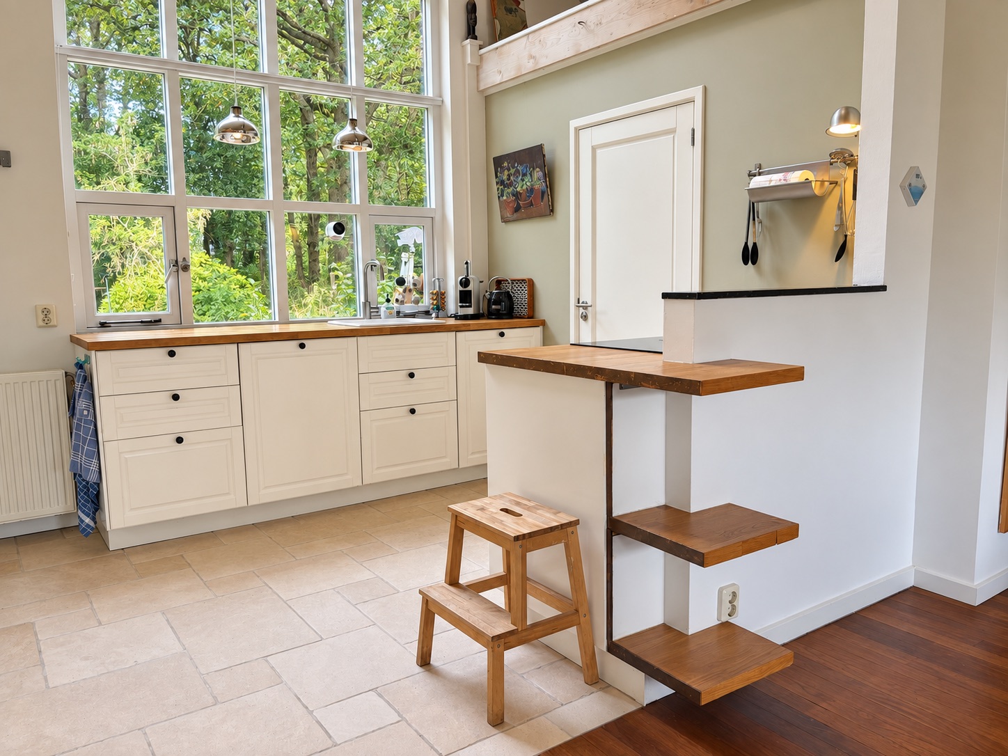The kitchen in morning light beneath the tall windows